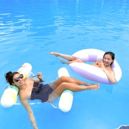 two women in floatables in a blue water pool