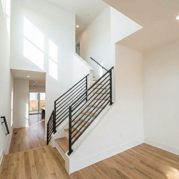 modern staircase in a sunlit, multi-level townhome interior